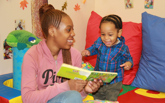 Mother and son reading a book together and smiling